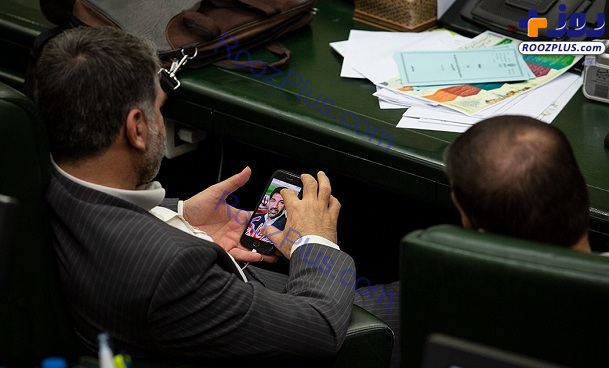 یک نماینده مجلس در حال بررسی طرح پوستر انتخاباتی+عکس