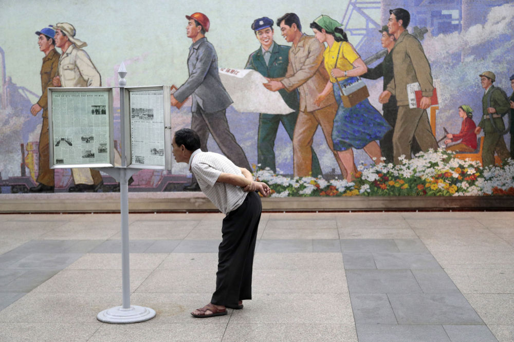 مسافر مترو در پیونگ یانگ در حال خواندن روزنامه+عکس