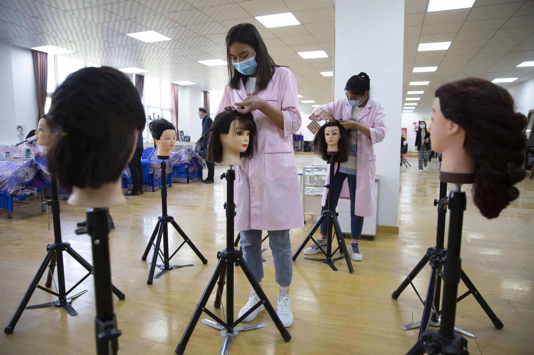 کار کردن دانش آموزان چینی در مدرسه روی گلاه کیس مانکن ها