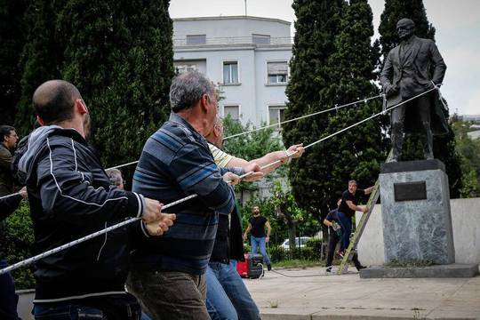 اعضا و هواداران حزب کمونیست یونان در حال پایین کشیدن مجسمه 
