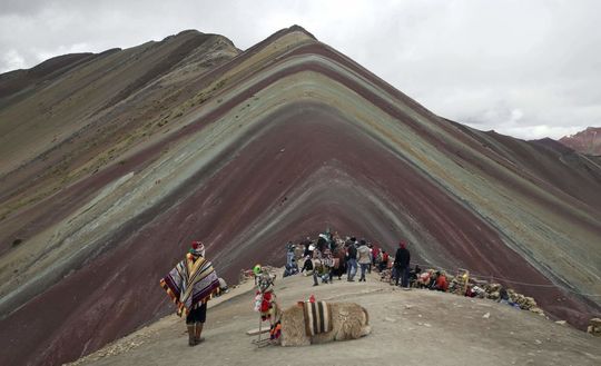 ساکنین محلی آند بالاما و توریست ها در مقابل کوه وینیکونکا در پرو