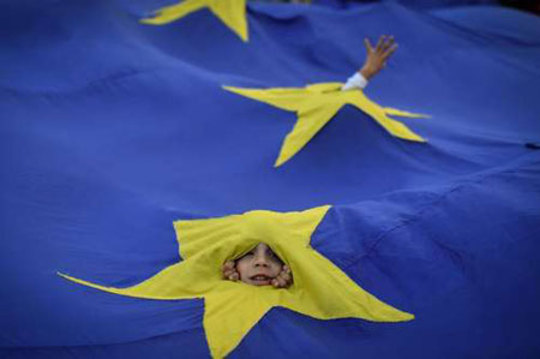 بازیگوشی بچه‌ها زیر پرچم اتحادیه اروپا در تظاهرات اعتراضی مخالفان حکومت رومانی برای استعفای نخست وزیر از قدرت- بخارست/ عکس: خبرگزاری فرانسه