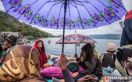 اندونزی خانواده هایی که منتظر گروه های امدادی هستند تا مفقودین حادثه غرق شدن قایق ۱۸۰ نفره در دریاچه گردشگری توبا را پیدا کنند. شمال سوماترا