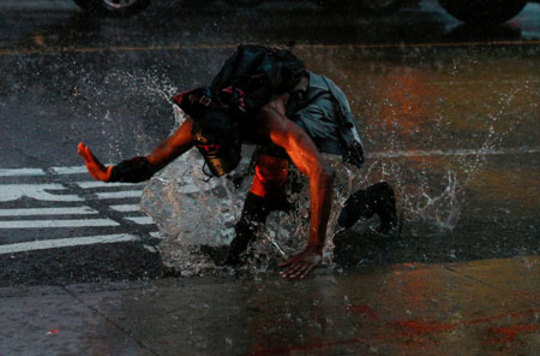لحظه افتادن یک فرد در گودال پر شده از باران در میدان تایمز نیویورک