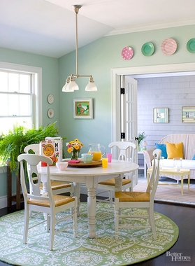دیوارهای سبز خسته کننده در اتاق ناهارخوری با اضافه کردن مجوعه ای از رنگ های سفید مثل میز و صندلی ناهارخوری  یک حس آرامش به این بخش از خانه بخشیده.
فرش گرد زیر میزناهارخوری که ترکیبی از رنگ سبز دیوار و رنگ سفید اشیاء استفاده شده در این بخش از خانه  که معرف سایه ای از رنگ سبز به عنوان رنگ قالب در این فضاست.