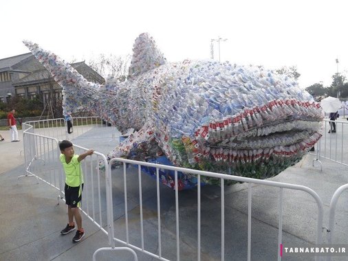 چین: کودکی در حال نگاه کردن به مجسمه ساخته شده از 40 هزار بطری پلاستیکی در اوشن پارک شاندونگ 
