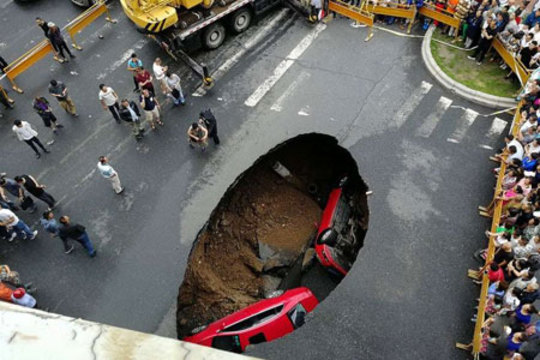 سقوط دو خودرو به یک گودال ایجاد شده در خیابانی در هاربین چین