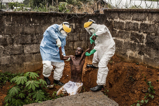 در سیرالئون در مرکز نگهداری از بیماران دچار ابولا، این مرد دچار توهم و جنون ناشی از بیماری شده و سعی کرده است که فرار کند. این بیمار، زمان کوتاهی بعد از گرفته شدن این عکس، درگذشت.