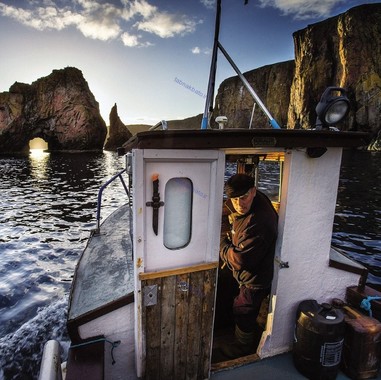 کاپیتان هنری اندرسون در یک قایق شکاری در میان صخره های یک جزیره در اسکاتلند.