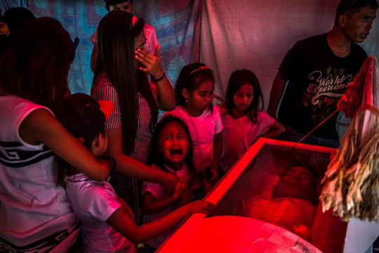 رودریگو دوترته- رئیس جمهور فیلیپین- بسیار جنجالی است و سیاست مشت آهنین علیه قاچاقچی‌ها را در پیش گرفته و به مکانیسم‌های معمول دستگیری و محاکمه و مجازات باور ندارد. در اینجا پدری را می‌بینید که دخترش برایش می‌گرید و ظاهرا یکی از همین کشته‌شده‌های قاچاقچی است.