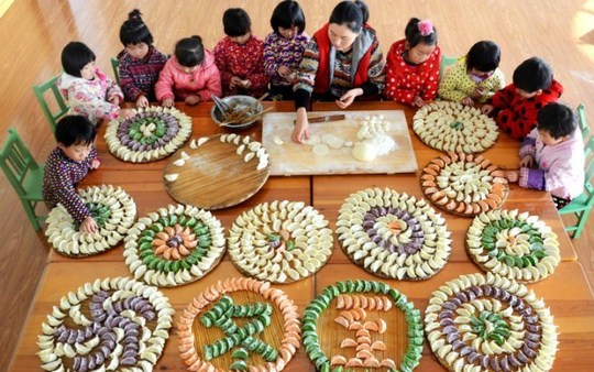 در چین، بچه های مهدکودک به مناسبت موسم انقلاب زمستانی نان فطیری تهیه می کنند