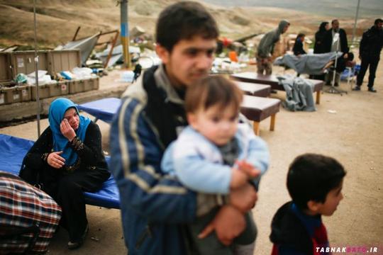 انتظار یک زن آواره‌ی عراقی برای رسیدن کامیون انتقال مردم به مکان های امن‌تر