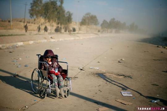 یک دختر معلول عراقی که با ترک خانه اقدام به فرار کرده است، در انتظار رسیدن کامیون انتقال