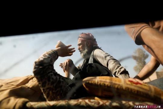 یک مرد آواره‌ی عراقی که در حال انتقال به مناطق امن است، دست خود را بالای صورت خود گرفته تا نور خورشید، چشمانش را اذیت نکند.