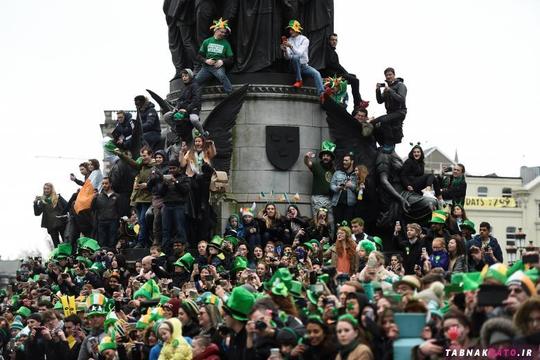 مردم در حال تماشای رژه‌ی روز سنت پاتریک در شهر دوبلین ایرلند