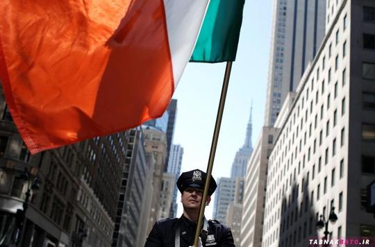 جوزف سانتوس؛ یک پلیس راهنمایی و رانندگی در شهر نیویورک در حال حمل پرچم ایرلند در راهپیمایی روز سنت پاتریک