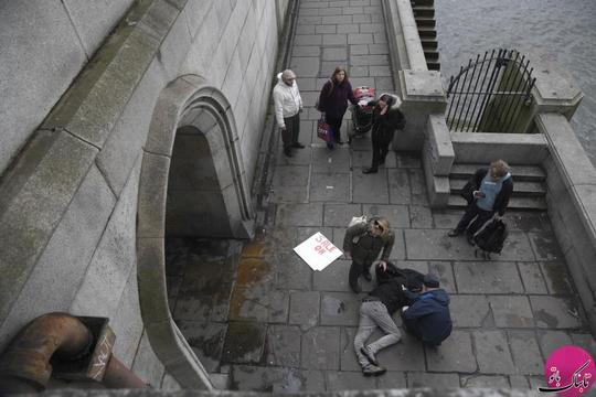 کمک‌رسانی به یک مرد مجروح در پیاده‌روی زیر پل وستمینیستر بریج شهر لندن