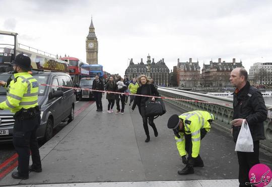 یک زن در حال عبور از زیر نوار عبور ممنوع پلیس پس از وقوع حادثه در پل وستمینیستر بریج شهر لندن بریتانیا