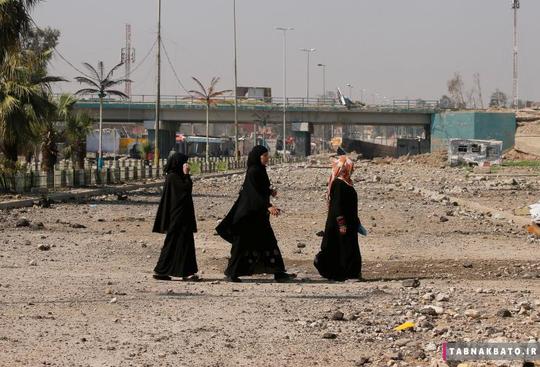 زنان عراقی در حال عبور از خیابانی در منطقه تحت کنترل نیروهای عراقی در غرب موصل.