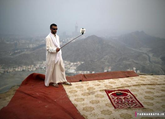 یک زائر مسلمان در موسم حج با استفاده از مونوپاد بر فراز کوه ثور در شهر مقدس مکه از خود عکس سلفی می‌گیرد. (19 سپتامبر 2015)