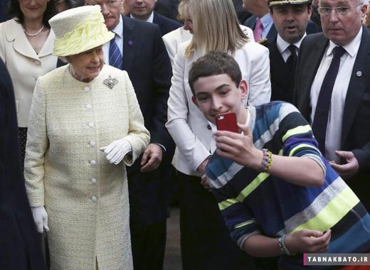 یک نوجوان محلی در بازار سرپوشیده سنت جورج شهر بلفاست ایرلند شمالی، در مقابل ملکه الیزابت (ملکه‌ی بریتانیا) اقدام به گرفتن عکس سلفی می‌کند. (24 ژوئن 2014)