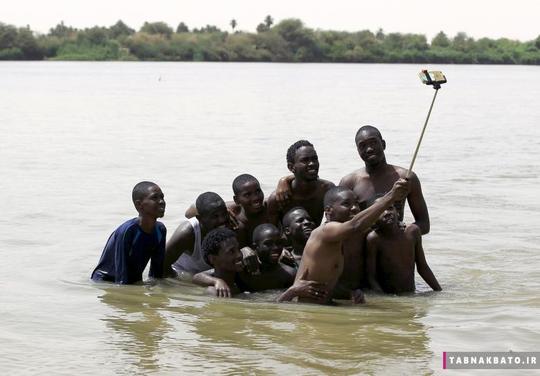 دسته‌ای از پسران جوان با استفاده از یک مونوپاد در آب‌های گل آلود رود نیل در خارج از شهر خارطوم سودان، از خود عکس سلفی می‌گیرند. (22 می 2015)