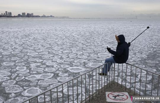 چالرز مارتینز با نشستن روی نرده‌های کنار دریاچه یخ زده‌ی میشیگان در شیکاگو از خود عکس سلفی می‌گیرد. (5 ژانویه 2015)