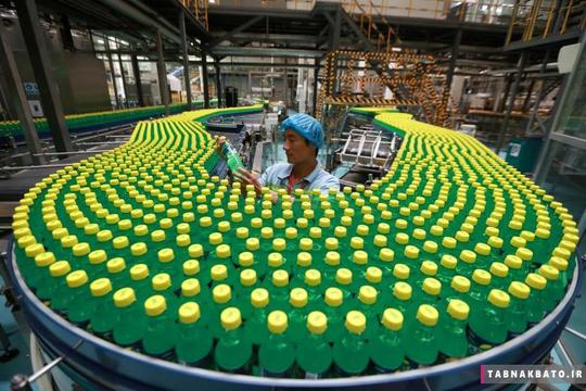 بررسی بطری‌های آب معدنی توسط یک کارگر در خط تولید کارخانه‌ای در شهر لوهه در استان هنان در کشور چین