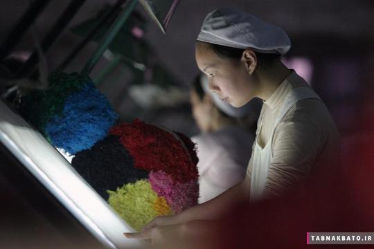 یک زن در حال کار در یک کارخانه نساجی در ژیانگفان در استان هوبی چین