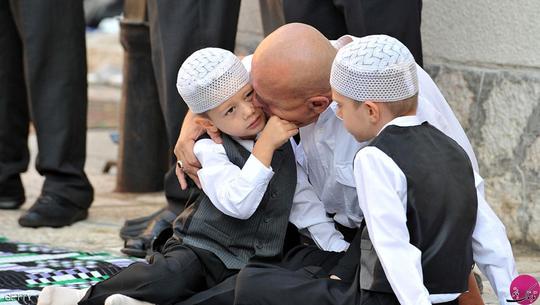 مرد بوسنیایی در حال بوسیدن فرزندش قبل از شروع نماز