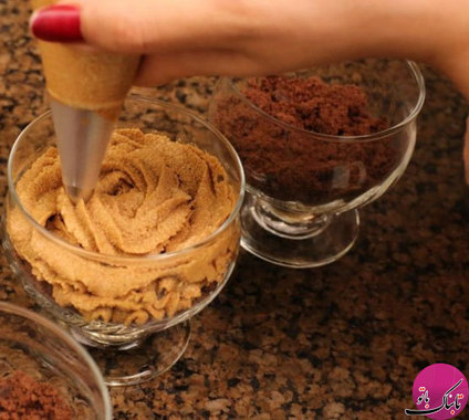 موس شکلاتی را در قیف شیرینی پزی ریخته و روی کیک‌های پودر شده می‌ریزیم