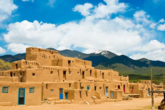 تائوس پوئبلو (Taos Pueblo)
یک نمونه معماری خشتی بی همتا در منطقه نیومکزیکو، تائوس پوئبلو، یک اجتماع فعال است که سعی در ادامه فرهنگ سنتی سرخ پوستی را تا امروز دارند.