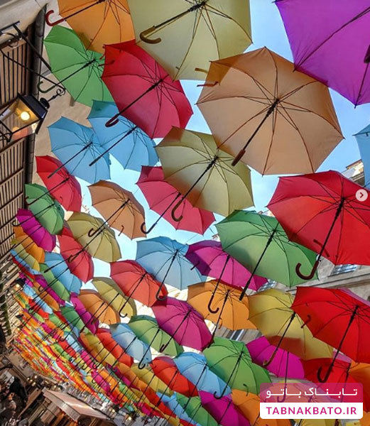 خیابانی پوشیده با چترهای رنگارنگ
