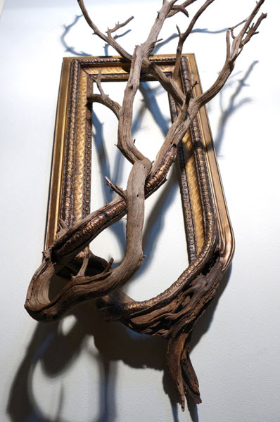 هنرمندی که با مهارت قاب‌های چوبی را با شاخه‌ها و ریشه‌های درختان پیوند می‌دهد