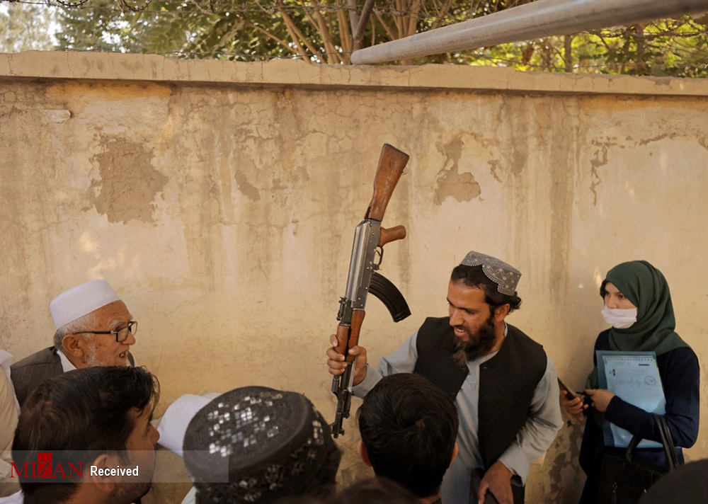 تهدید با اسلحه برای برقراری نظم صف پاسپورت در کابل +‌ عکس