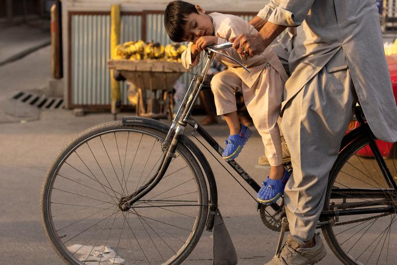 تصویری جالب از خواب پسربچه افغان روی دوچرخه