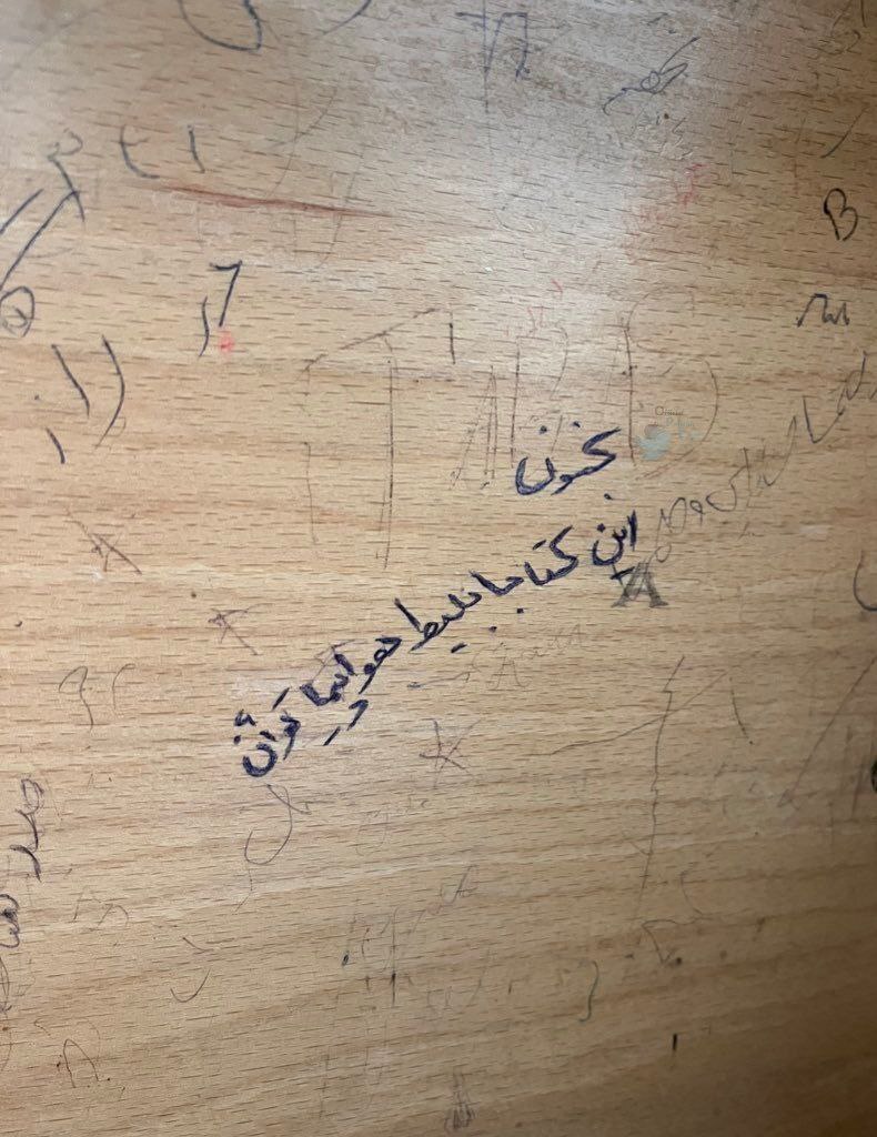 نوشته غم‌انگیز روی میز کتابخانه یک دانشگاه