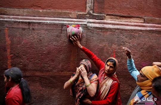 زنان هندو در حال دست کشیدن روی دیوار بیرونی معبد هستند تا در فستیوال مذهبی هولی در ورینداوان در ایالت شمالی اوتار پرادش هندوستان شرکت کنند.