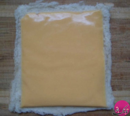 پنیر خامه‌ای یا پنیر چدار را روی نان تست قرار می‌دهیم
